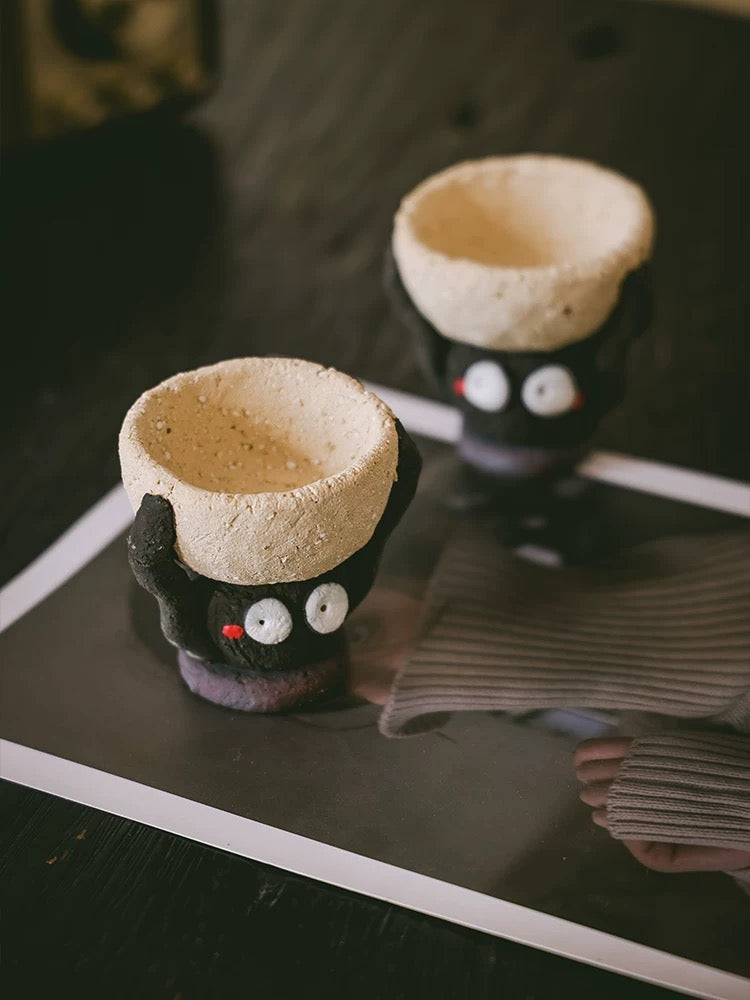 Two handmade ceramic Soot Spirit candle holders with textured cream bowls displayed on a table.