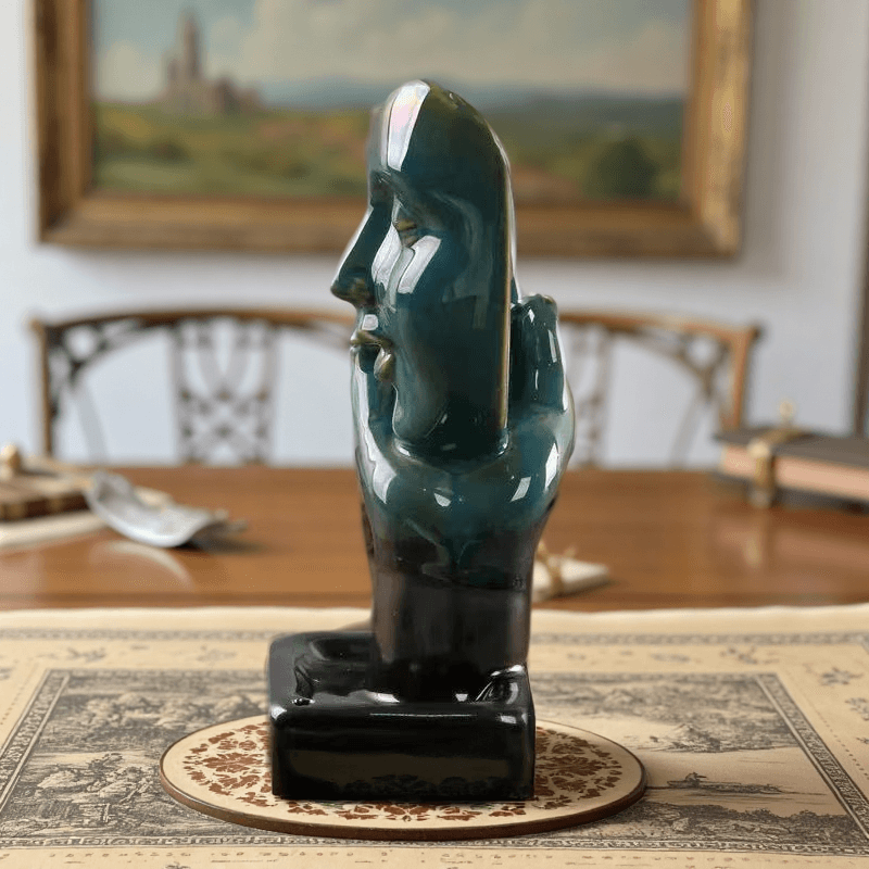 Side view of Abstract Face Backflow Incense Burner placed on a patterned mat in a classic dining room setting.