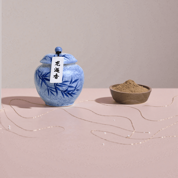 Ambergris handcrafted natural incense powder stored in a blue ceramic jar, with a small amount placed in a wooden bowl to show the powder.