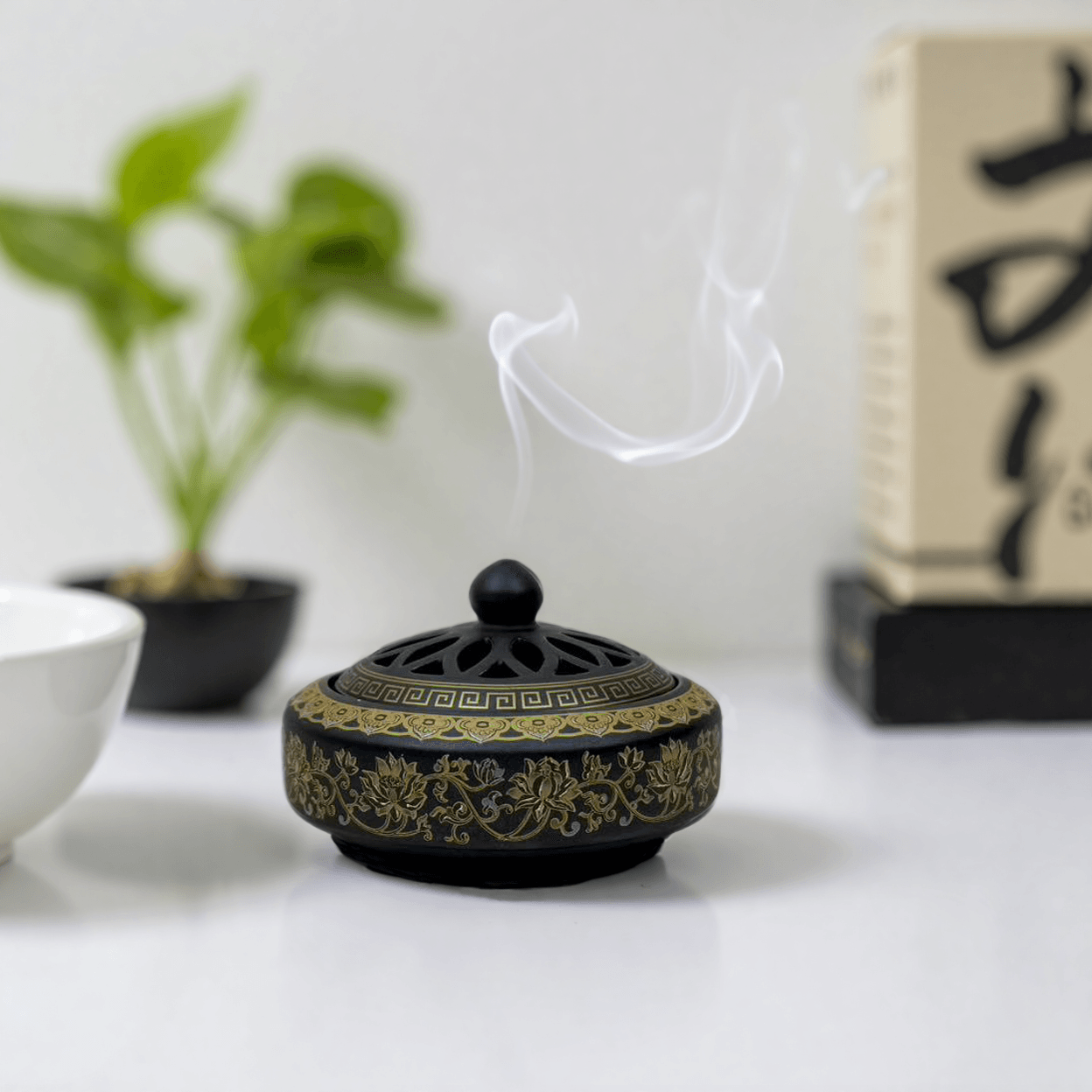 Antique cloisonné incense burner with a domed cut-out lid, featuring gold floral patterns on black enamel, suitable for incense powder and cones.