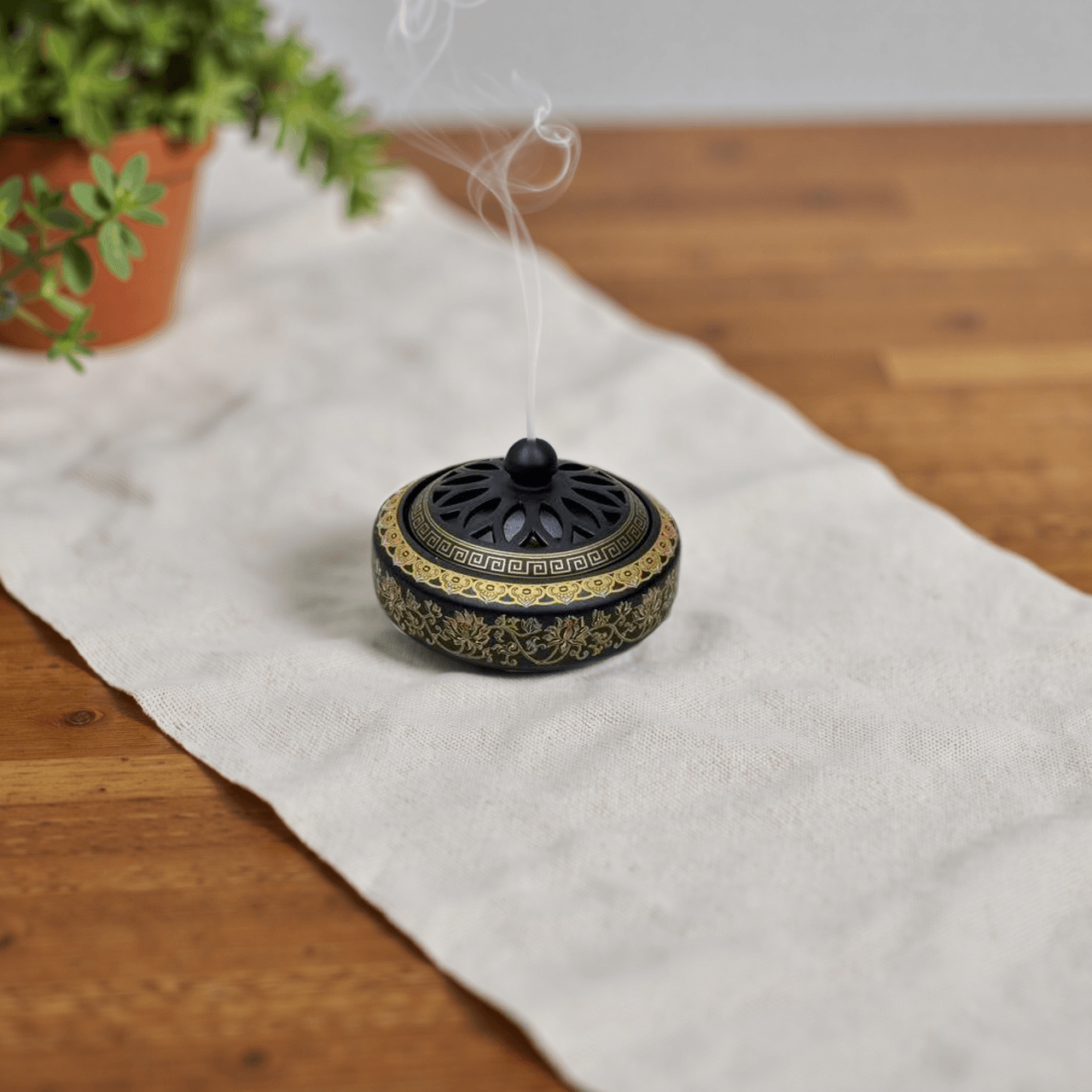 Antique cloisonné metal incense burner with a vented domed lid and gold floral enamel detailing, designed for incense powder or cones.