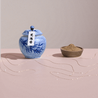 Ambergris incense powder next to a wooden bowl that serves to display the incense powder beside the jar