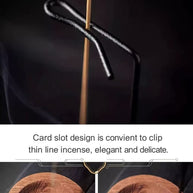 Close-up of the backflow incense burner’s hook and card slot holding a thin stick, with wooden ash dish detail and instructional overlay text