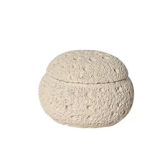 Top view of handmade beige cement incense burner lid with crater-like porous texture and natural seam line for cone incense burning