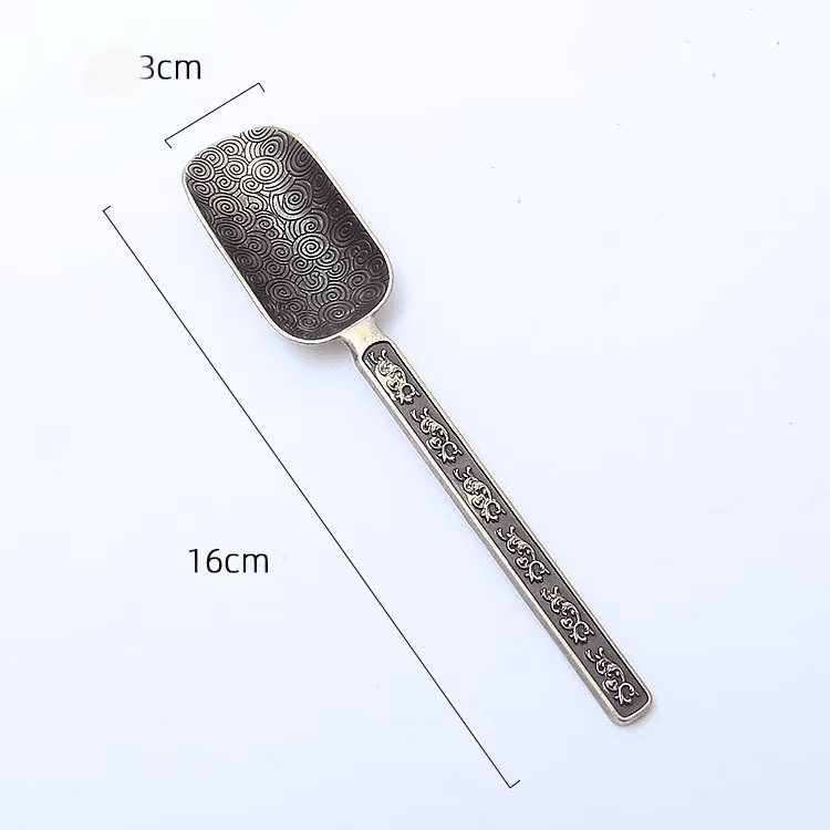 Brass incense scoop spoon measuring 16 cm in length with 3 cm wide spoon head, featuring engraved floral pattern, shown on white background