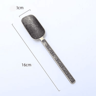 Brass incense scoop spoon measuring 16 cm in length with 3 cm wide spoon head, featuring engraved floral pattern, shown on white background
