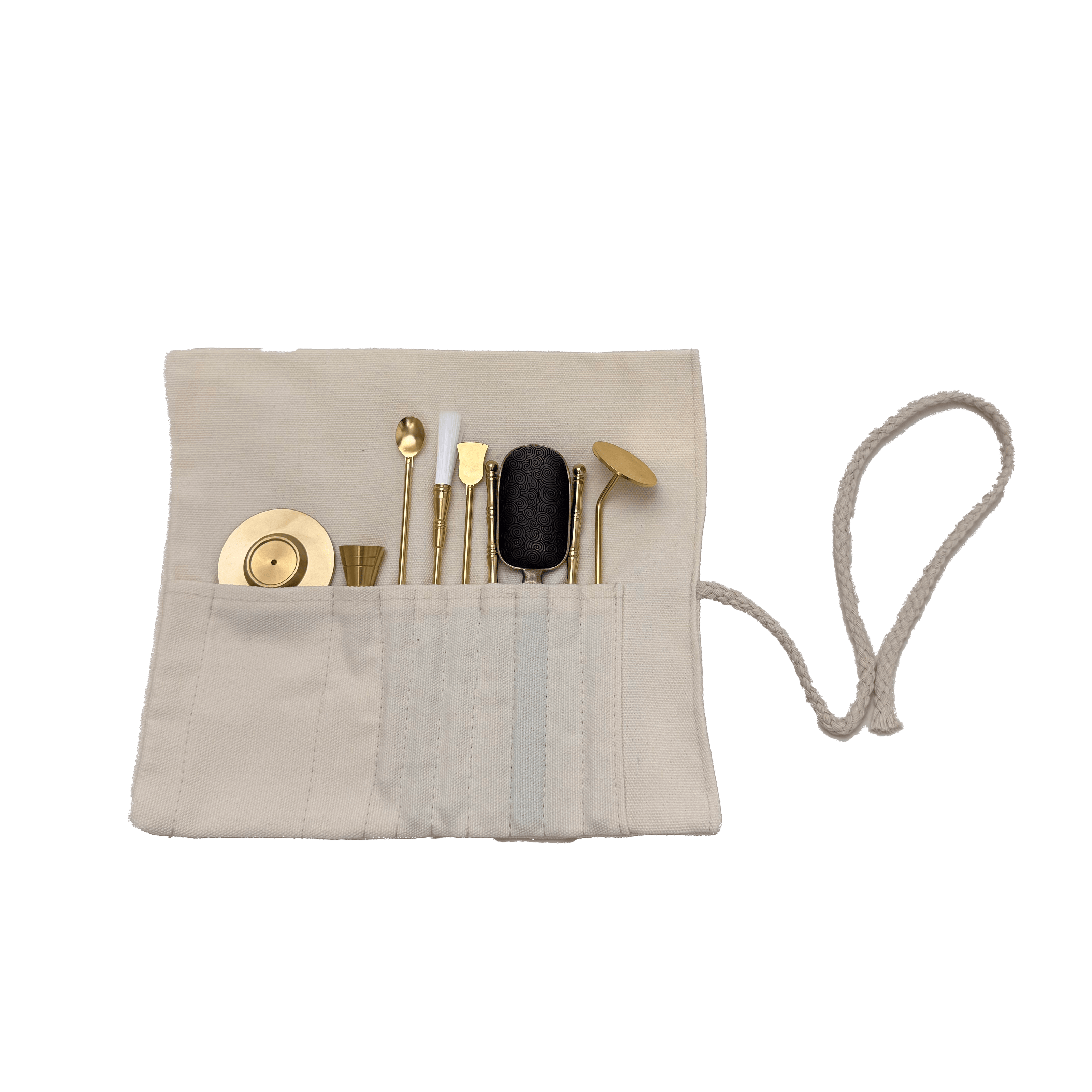 Top view of brass incense tool kit neatly arranged in cotton storage wrap, showing spatulas, tongs, press, and spoon tools on transparent background