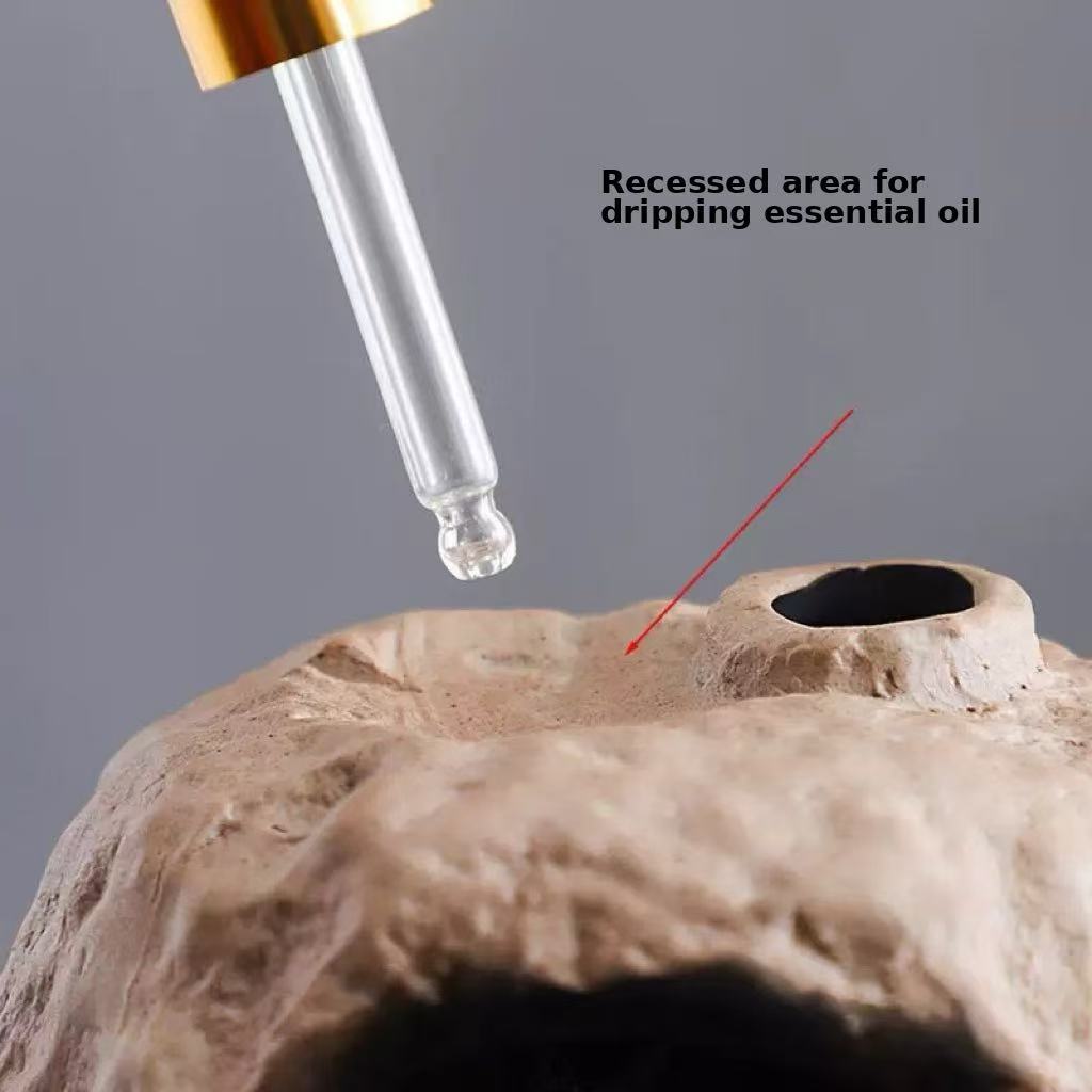 Close-up of handmade ceramic incense burner with recessed area for dripping essential oil, shown with dropper applicator for multifunctional use