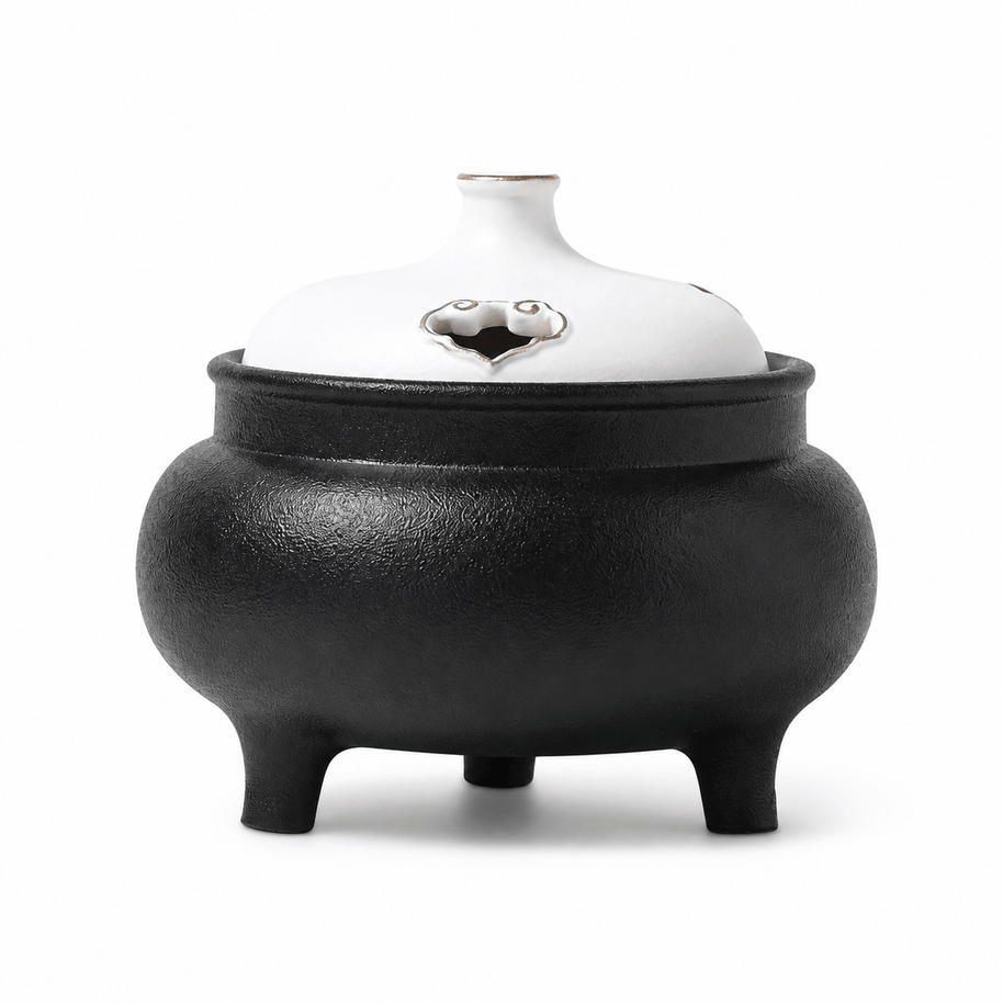 Classic black and white ceramic electric incense burner with a lidded three-leg design for flameless incense heating and home fragrance.