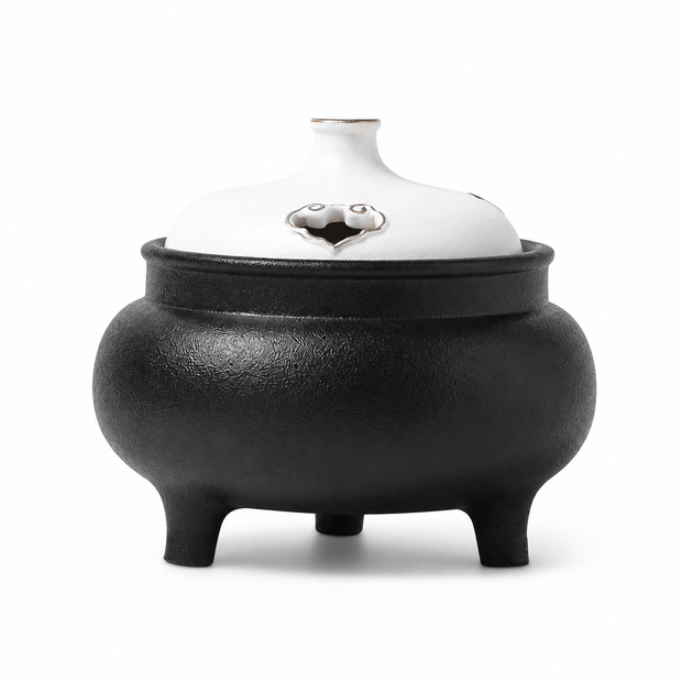 Classic black and white ceramic electric incense burner with a lidded three-leg design for flameless incense heating and home fragrance.