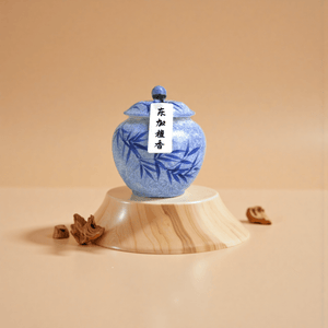 Dongjia sandalwood incense powder in a blue ceramic jar, made from pure Tongan sandalwood, shown with powdered form on a wooden base.