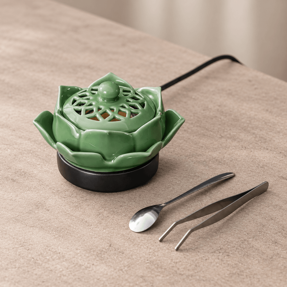 Angled view of a green lotus electric incense burner showing its patterned lid, layered petals and black base.