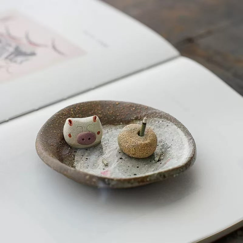 Handmade ceramic incense holder with pig figurine, artisanal incense burner for home decor, aromatherapy, and relaxation.
