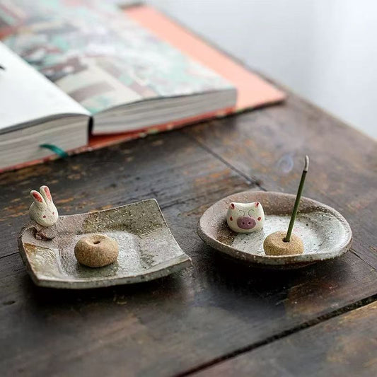 Handmade ceramic incense holder featuring rabbit and pig figurines, artisanal incense burner for home decor, yoga, and meditation.
