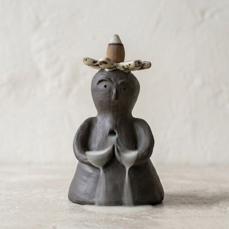 Handmade ceramic backflow incense burner statue with a flower crown and soft smoke waterfall effect.