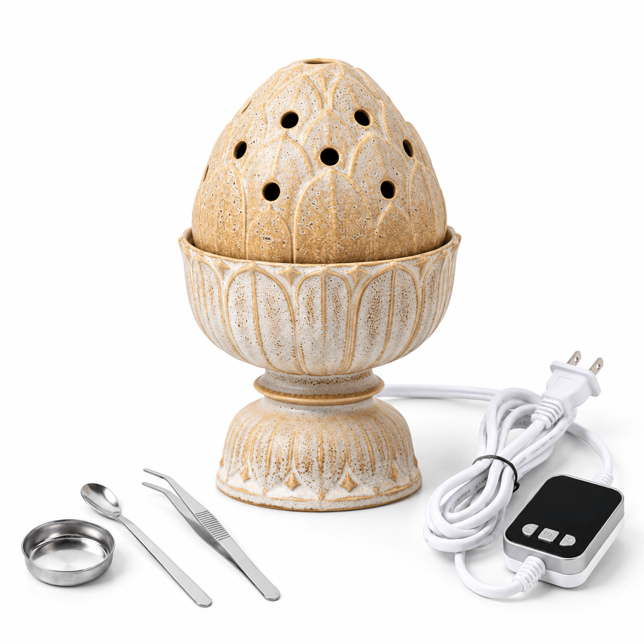 Beige lotus ceramic electric incense burner with digital controller, power cord, metal dish, spoon and tweezers on white.