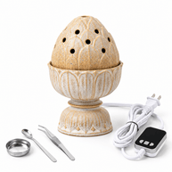 Beige lotus ceramic electric incense burner with digital controller, power cord, metal dish, spoon and tweezers on white.
