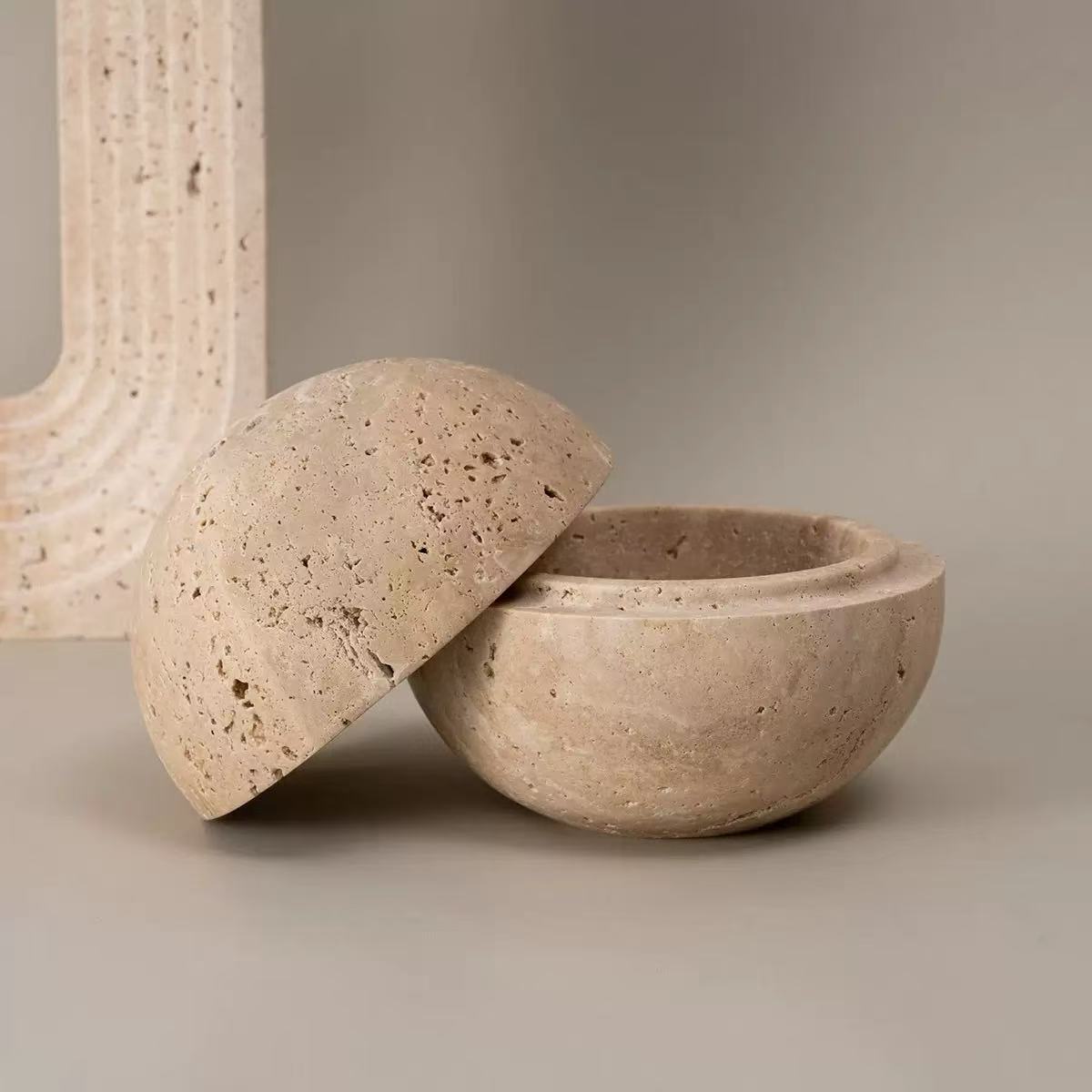 Natural travertine incense burner opened to show inner chamber, displayed at an angled side view on minimalist background