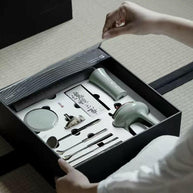 Person opening Incense Bath Ceremony Set showing celadon incense burner and organized tools in foam inlay inside black gift box