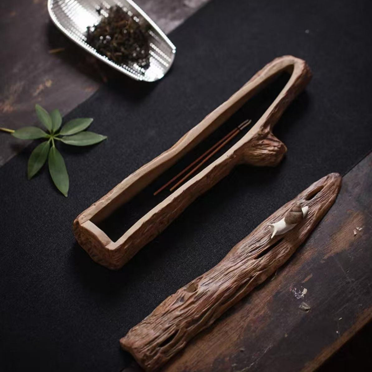 Snail-inspired ceramic incense burner with opened wooden base, showcasing stick incense inside