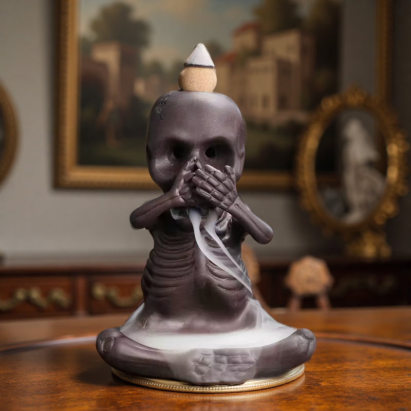 Single skeleton incense burner in "speak no evil" pose with smoke flowing from mouth.