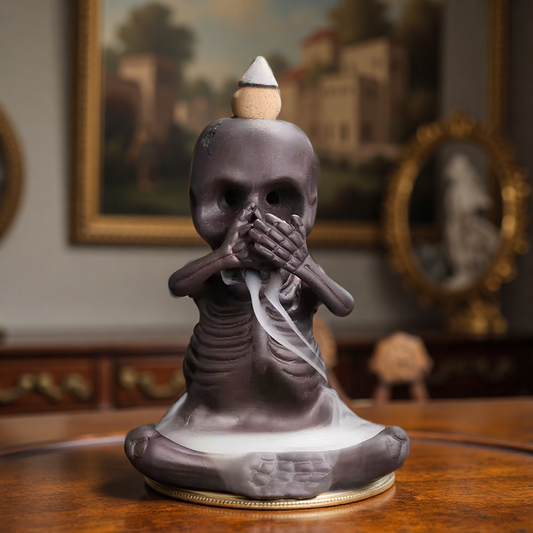Single skeleton incense burner in "speak no evil" pose with smoke flowing from mouth.