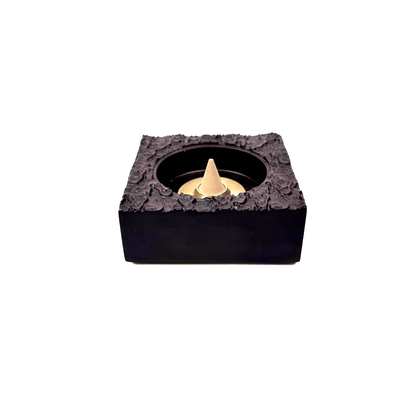 How to use demonstration of vintage black ebony incense burner with cone incense placed in center of burner base, photographed on white background