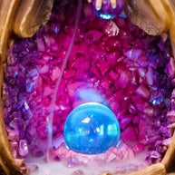 Close-up of wizard backflow incense burner showing glowing crystal ball and smoke