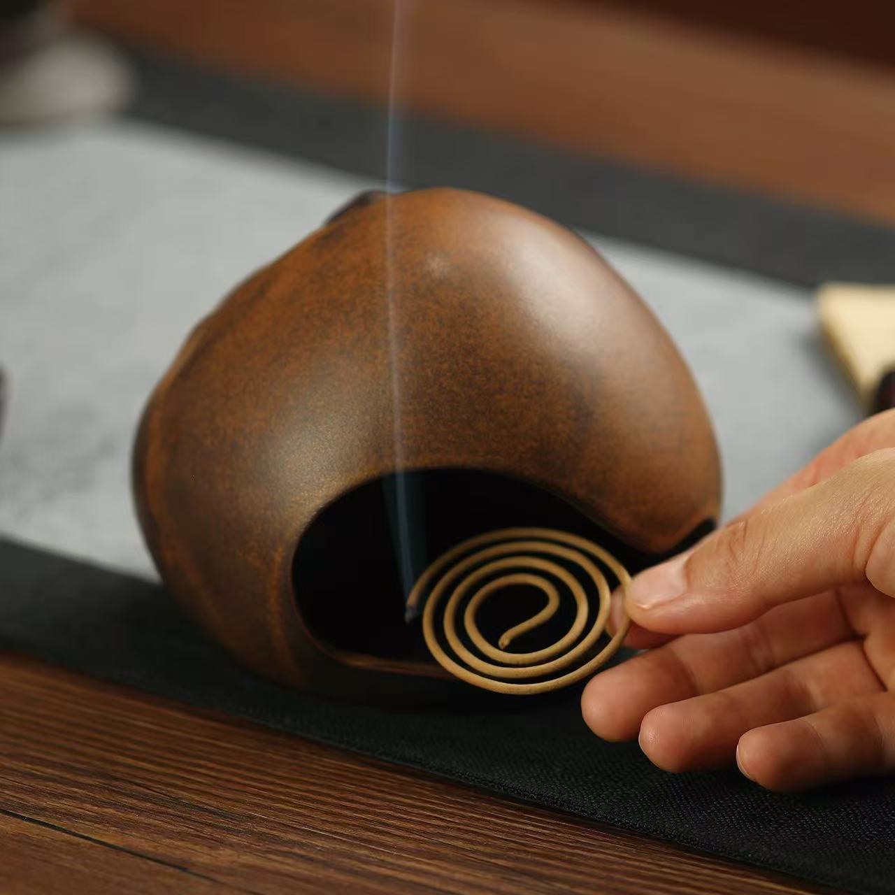Placing a spiral coil incense into the yawning face incense burner for use