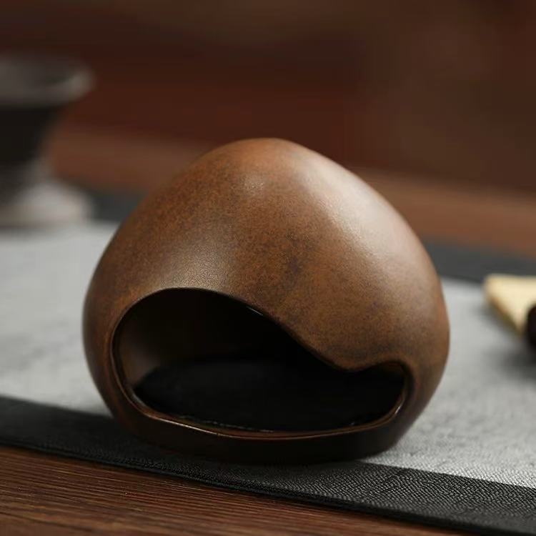 Back view of yawning face incense burner with a smooth ceramic surface and dark glaze finish
